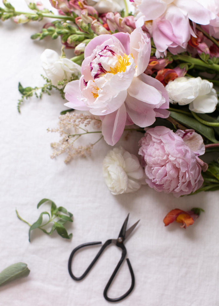 Flowers and snips on a worktable in preparation for making boutonnières