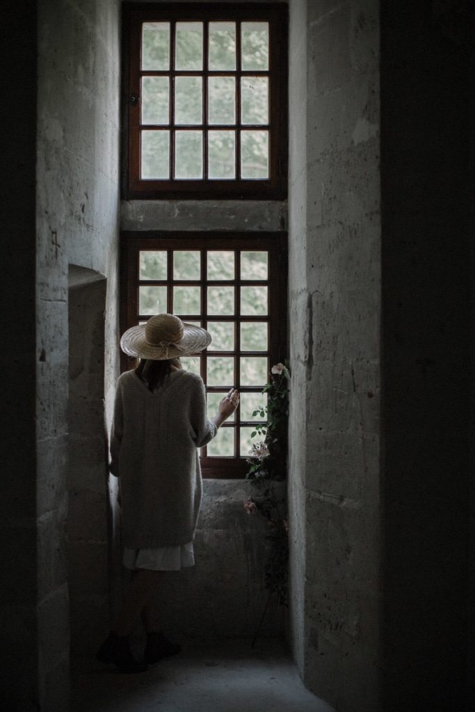 A photo of a model looking out of a window at The Secret Garden