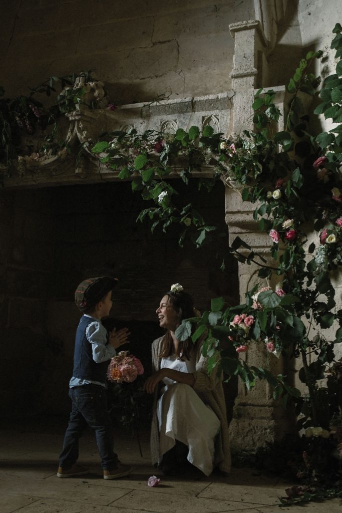 A woman and child laugh beneath floral mantel design at The Secret Garden retreat