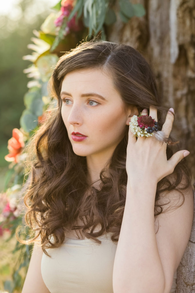 Flowers wrap around a tree above a model for a floral photoshoot by Chelsa Larson 