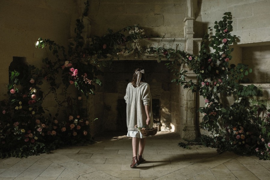 A model walks toward a floral mantel design by Laetitia Mayor