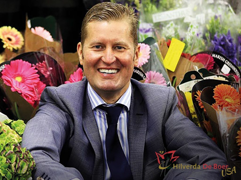 Marco Groot sits with bundles of fresh flowers