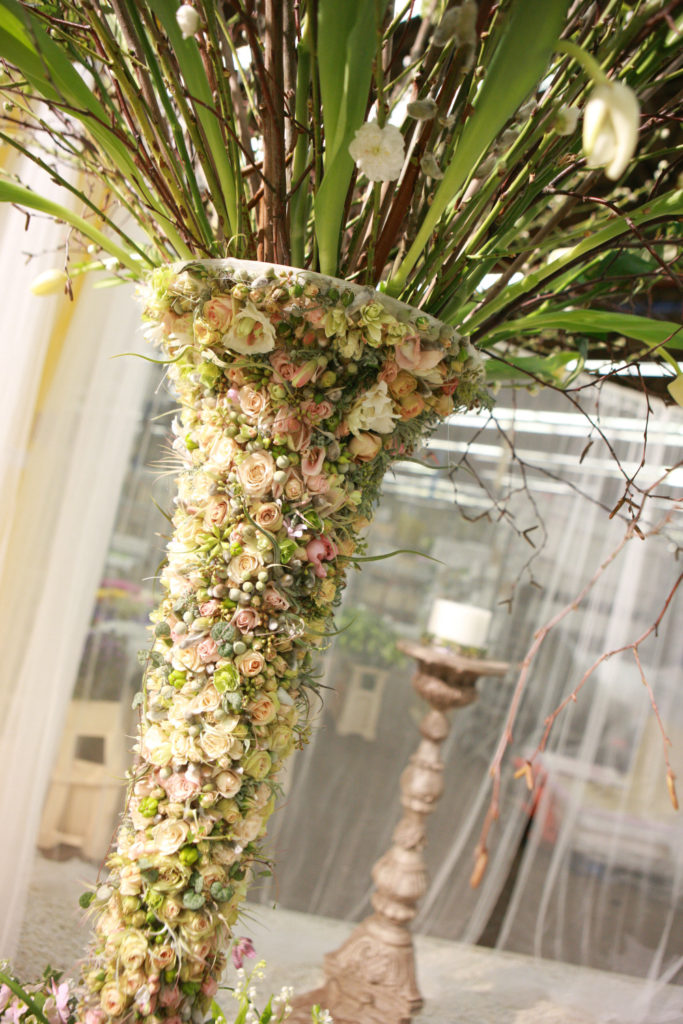 A tall flower-covered vase by Zita Elze