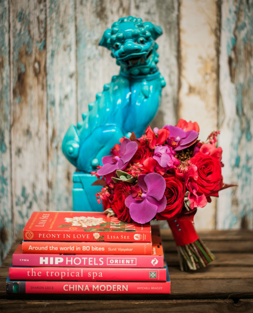 A red bouquet in front of a teal dragon statue by Nick Priestly