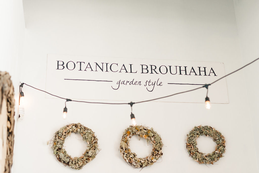 3 wreaths hang below the Botanical Brouhaha Garden Style sign