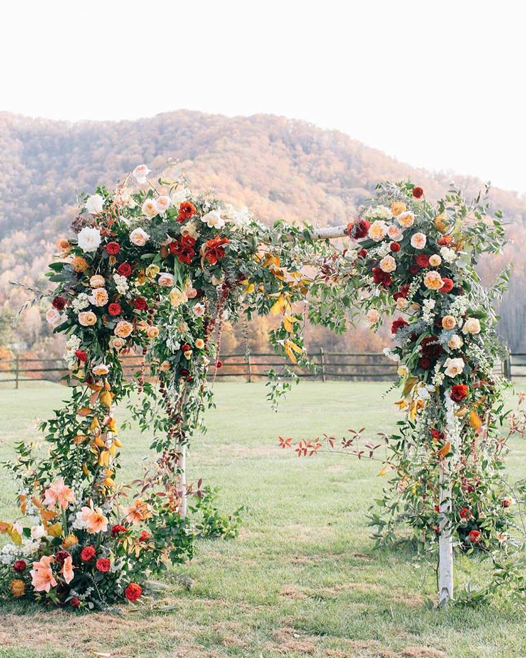 A rustic floral arch in a field by Eatherley Schultz