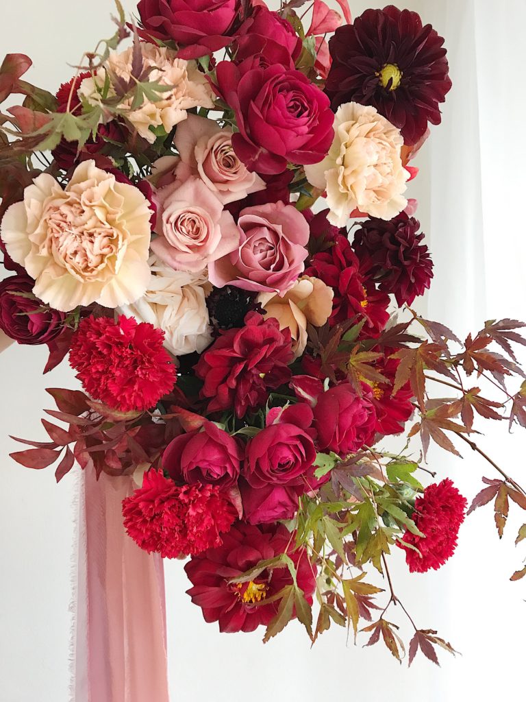 A large red floral arrangement by Cara Fitch