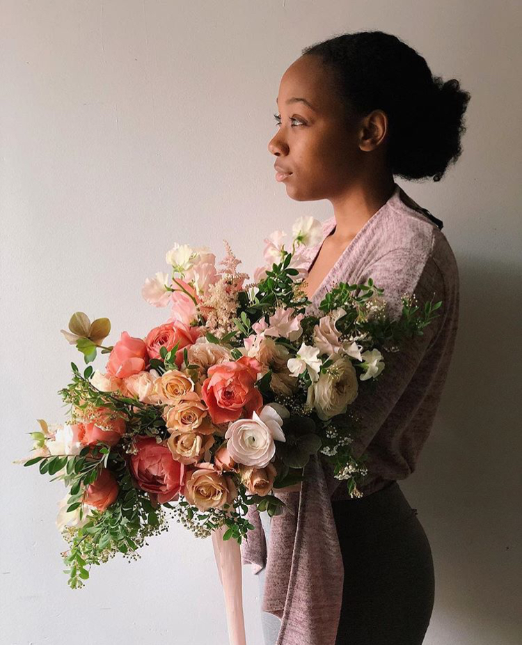 A model holding a large, pink bridal bouquet by Teresa Fung