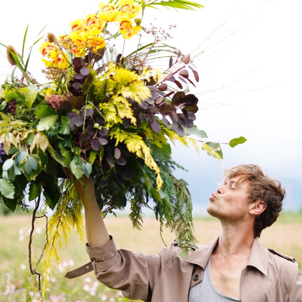 Phil John Perry holds a large floral arrangement 