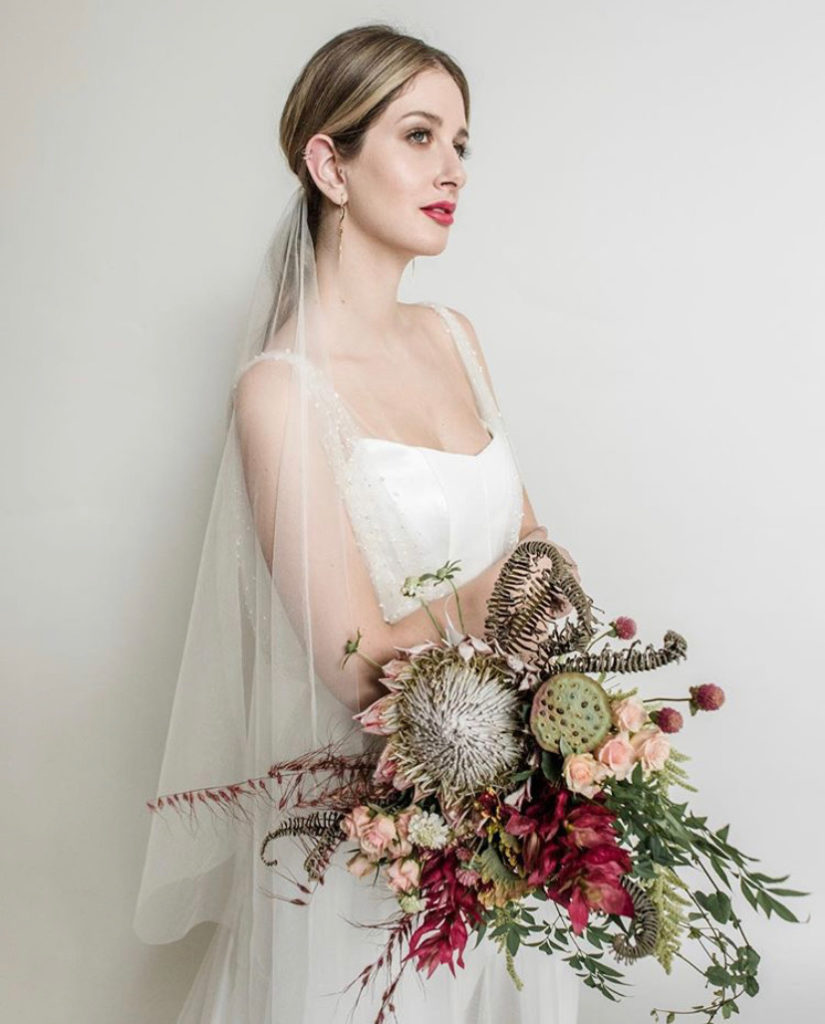 A bride holding a bridal bouquet by Lucia Milan
