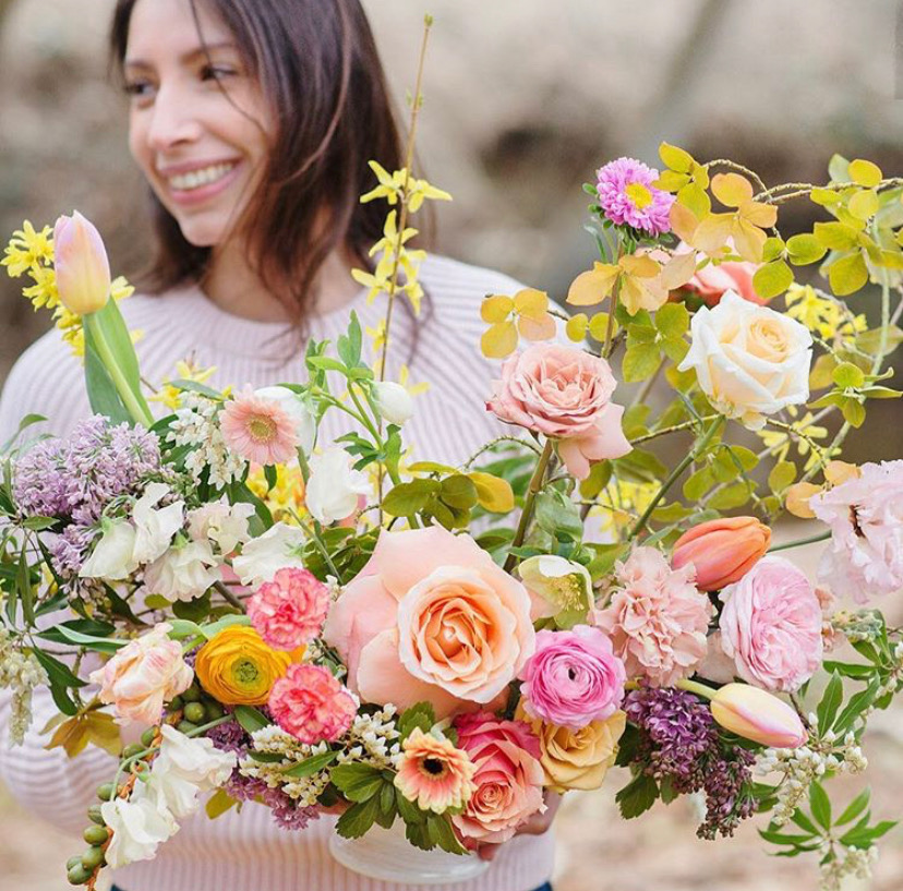 Nicole Rossi holding a vibrant arrangement of flowers