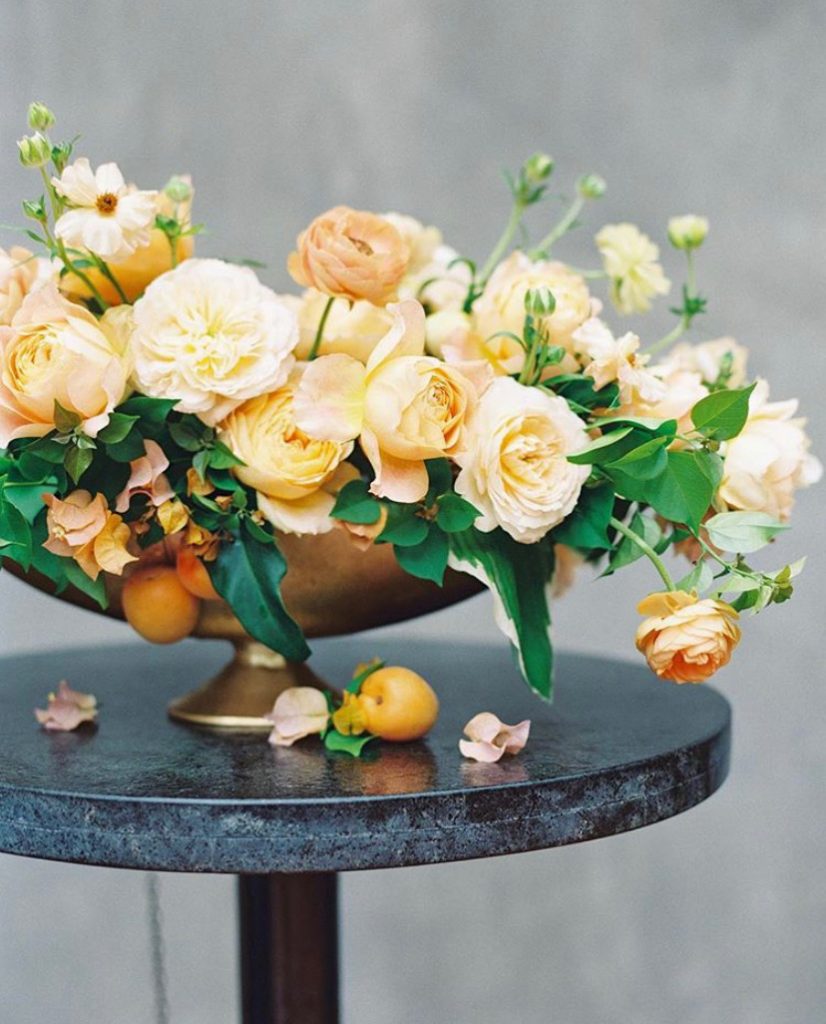 A yellow floral arrangement in a gold container by Michelle Hodges