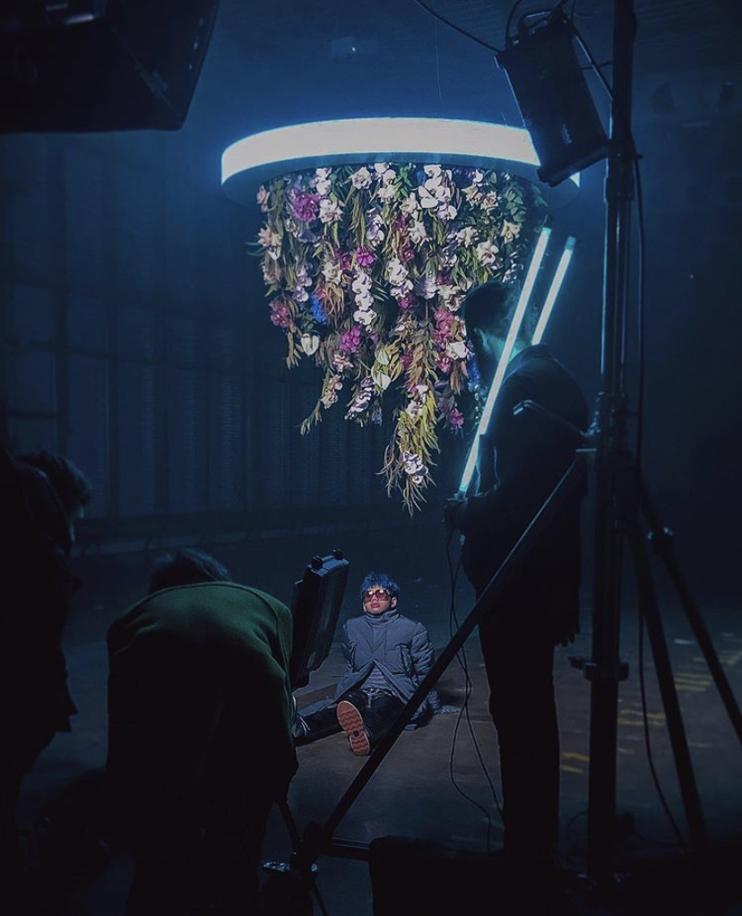 A Graeme Corbett photoshoot with a model beneath a hanging floral arrangement