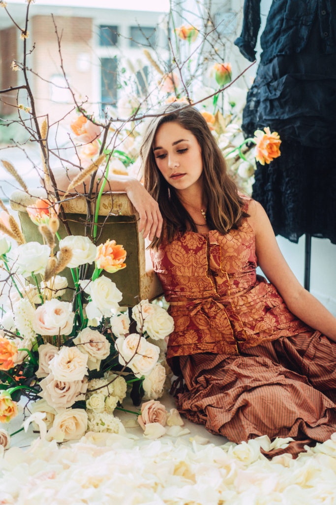 Model sitting in front of On a Limb floral installation in Charleston storefront