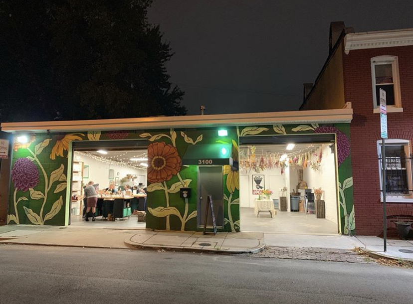 Local Color Flowers studio owned by Ellen Frost with large flower murals on the front walls in Baltimore at night