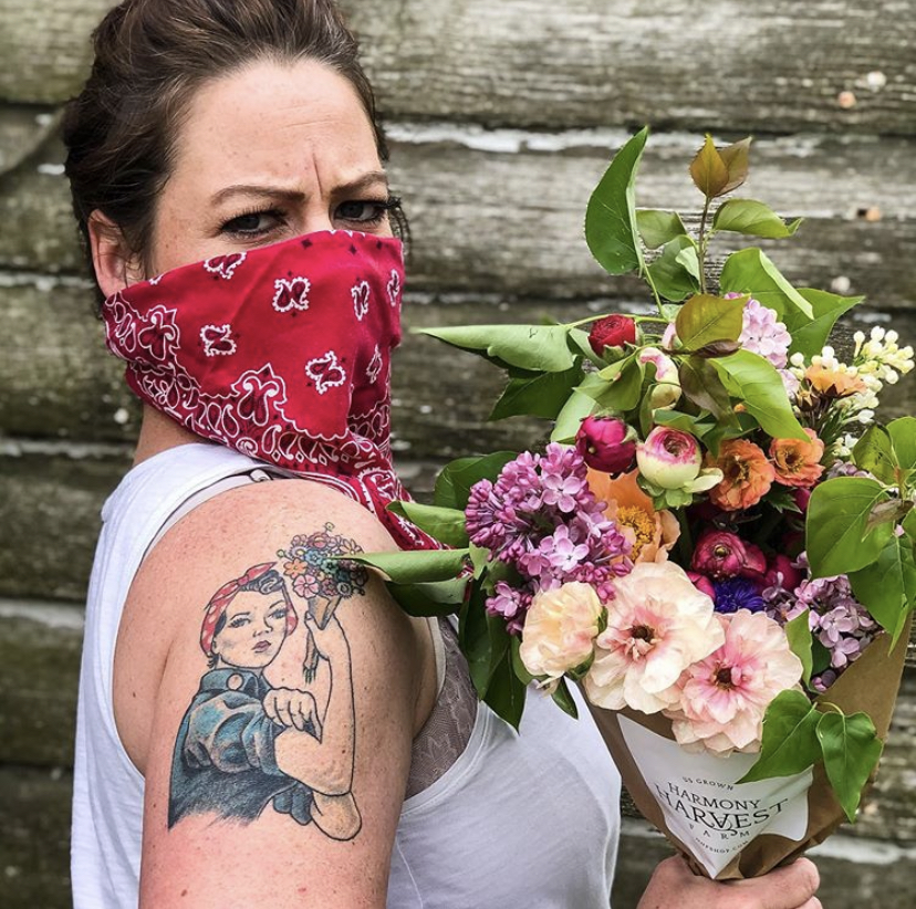 Owner Jess of Harmony Harvest Farm with bouquet of flowers she grew and wearing a COVID mask