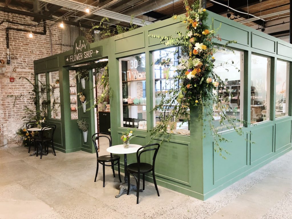 Amelia's Flower Shop storefront resembling a Paris market with bistro tables outside