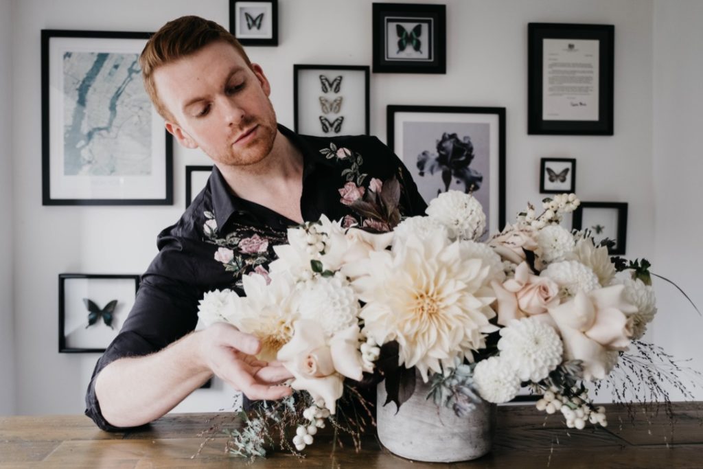 Florist Joseph Massie works on a ivory flower arrangement of dahlias and roses