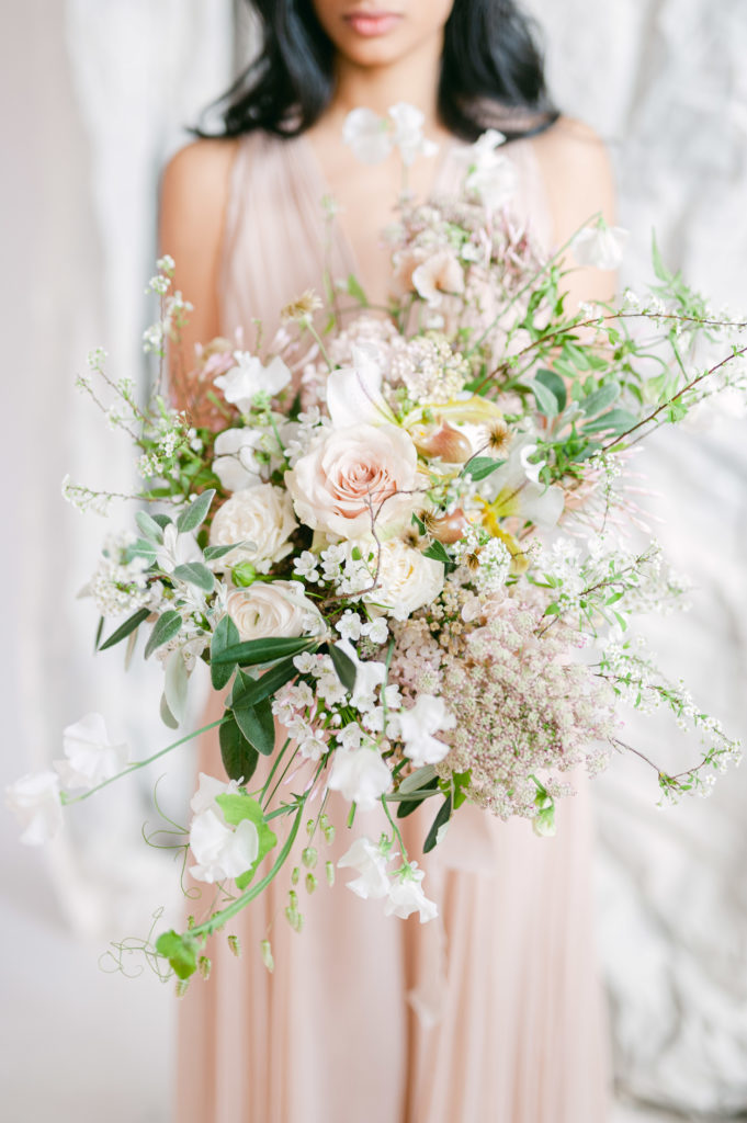 Bride holding a garden style bridal bouquet of neutral flowers from Joseph Massie's Online Studio Course