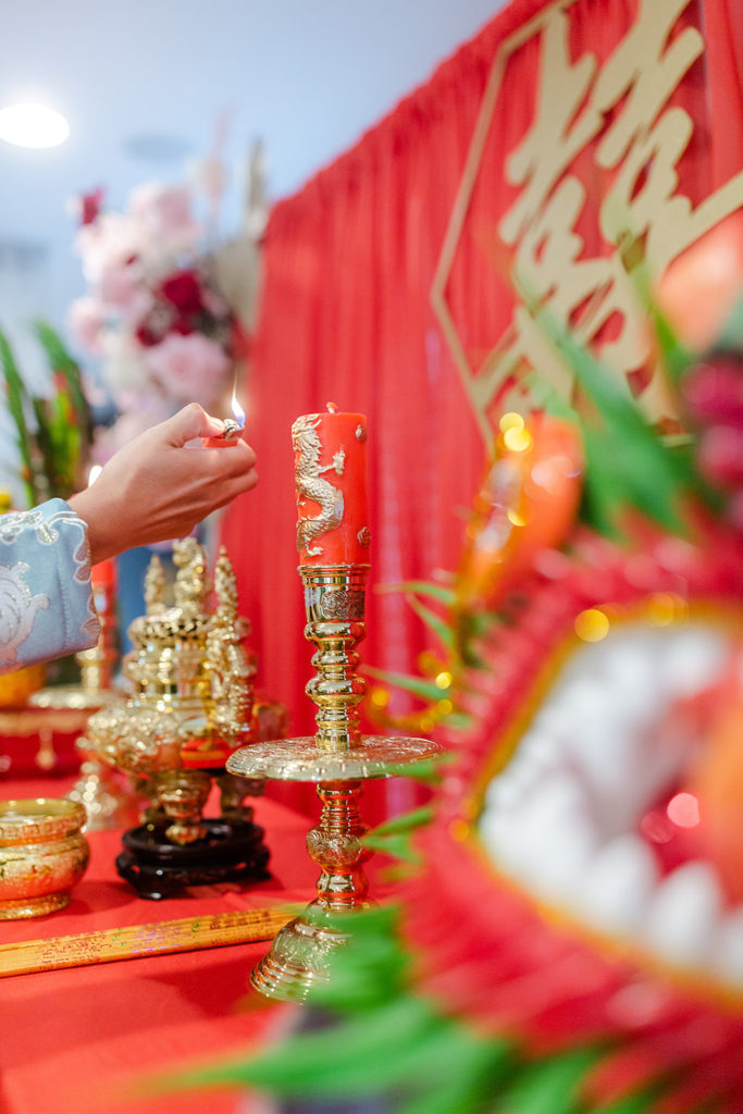 Lighting candles on the altar at a traditional Vietnamese wedding tea ceremony