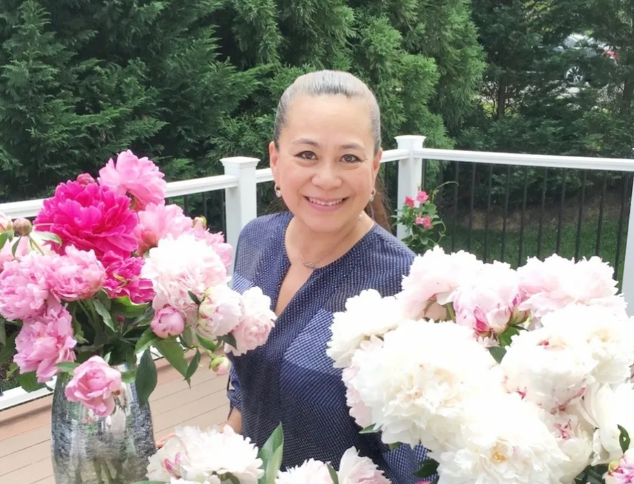 Florist KimBang Nguyen stands behinds vases peonies on outside deck and speaks about the importance of preserving the Vietnamese wedding tradition