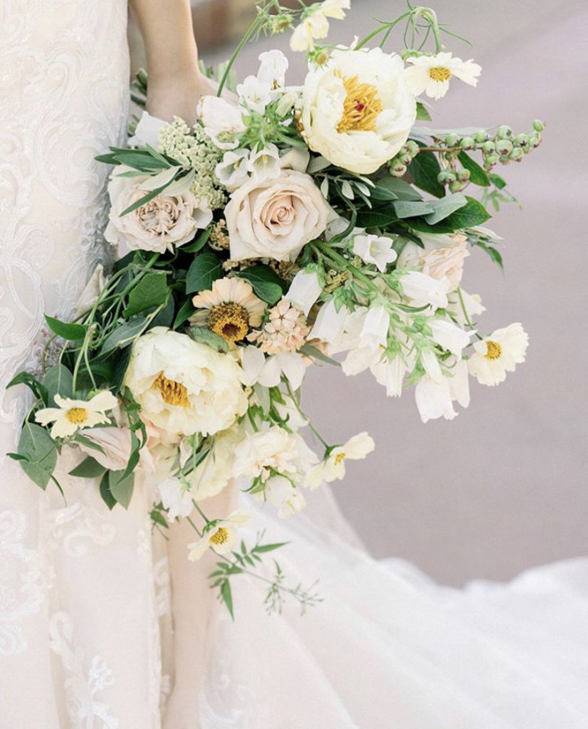 Bride holding bridal bouquet of ivory flowers designed by Lily Roden Floral Design