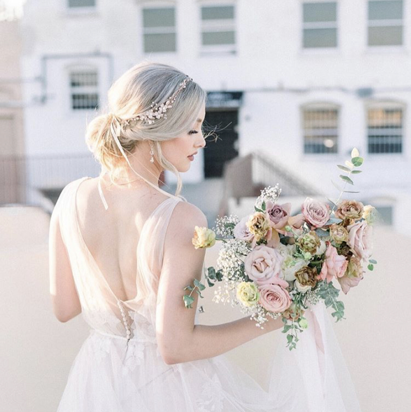 Bride holding a mauve bridal bouquet of roses, eucalyptus, and lisianthus designed by Lily Roden Floral Design