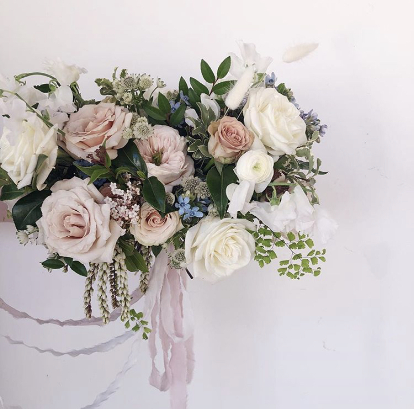 Hand-tied bouquet of roses, maidenhair fern, bunny tails, and tweedia designed by Lily Roden Floral Design