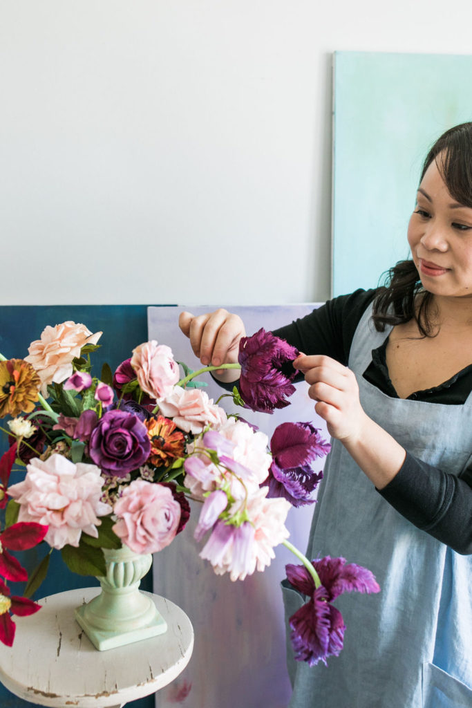 Jessie Chui, a paper florist arranges parrot tulips in a paper flower composition