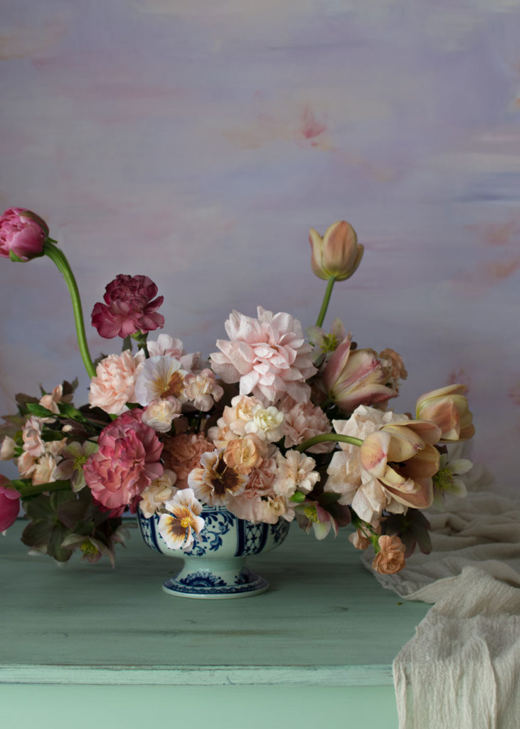 A compote bowl containing both fresh flowers and paper flowers 