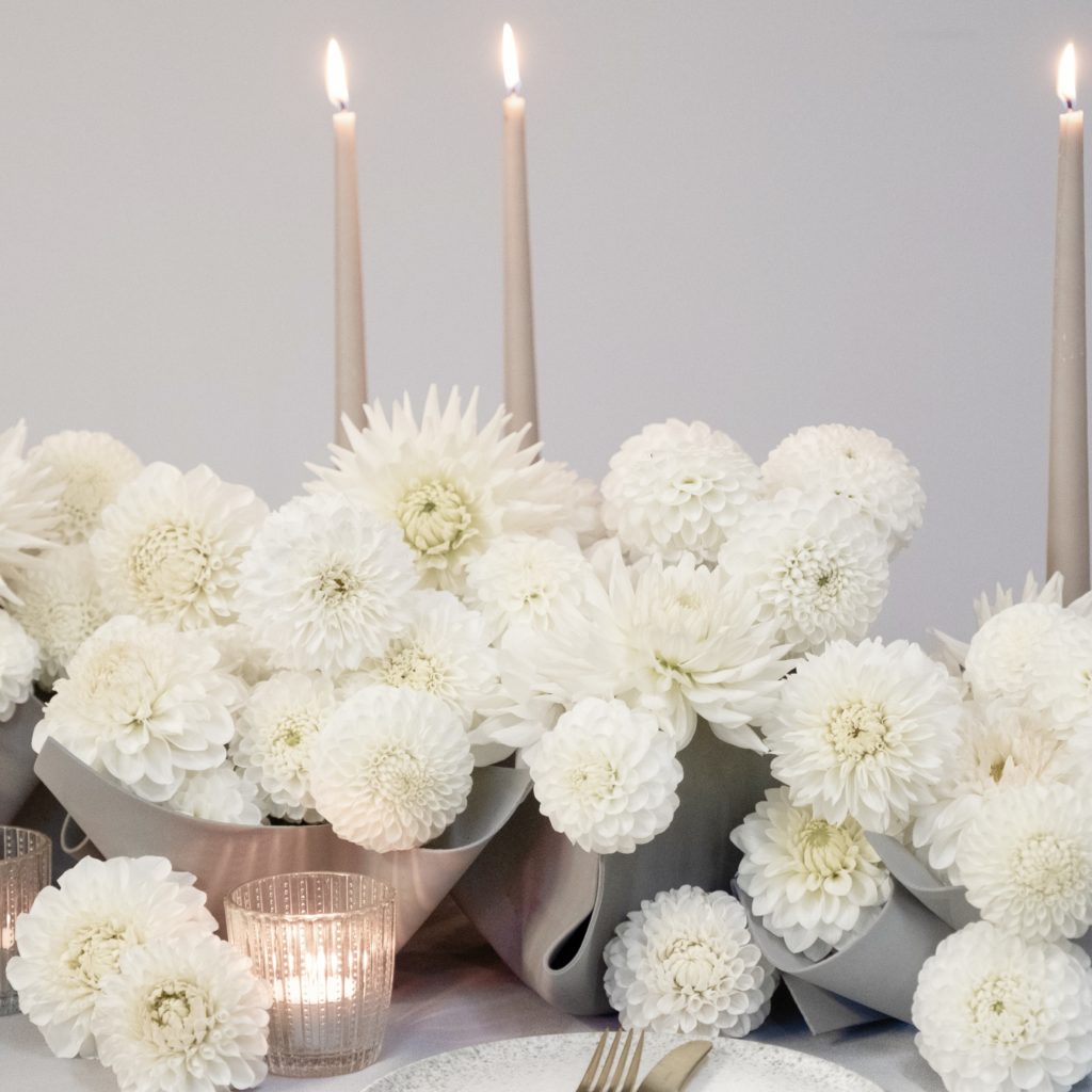 White dahlias in grey art foam covered glass vases make a modern tablescape