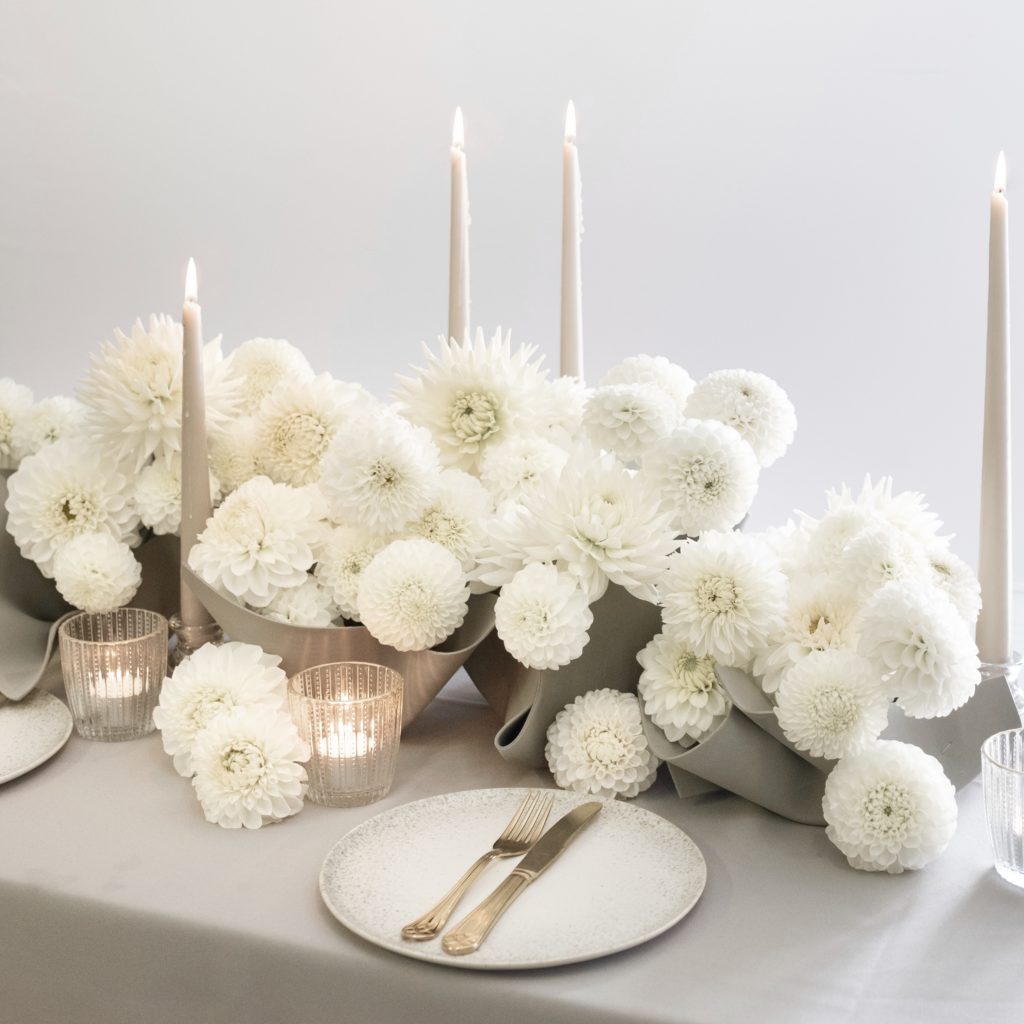 Completed monochromatic white tablescape of dahlias and candlelight