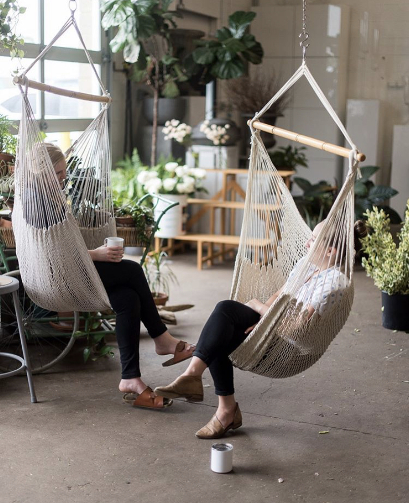 Team members at Sweet Root Village take a break in hanging macrame chairs
