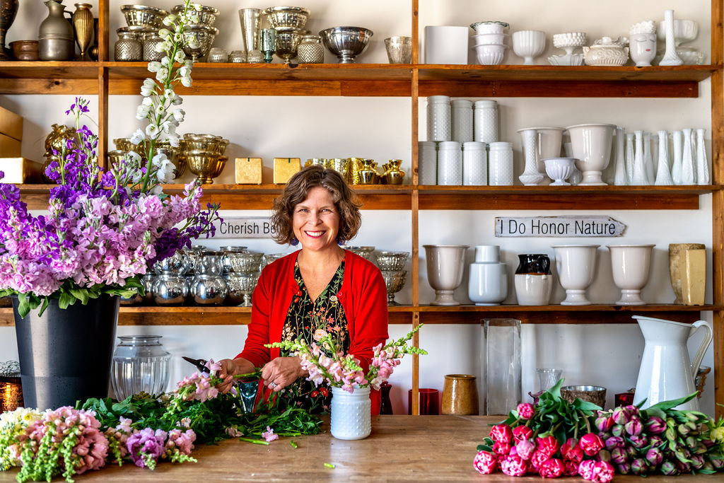 Ellen Frost, owner of Local Color Flowers, designing in her studio with local flowers