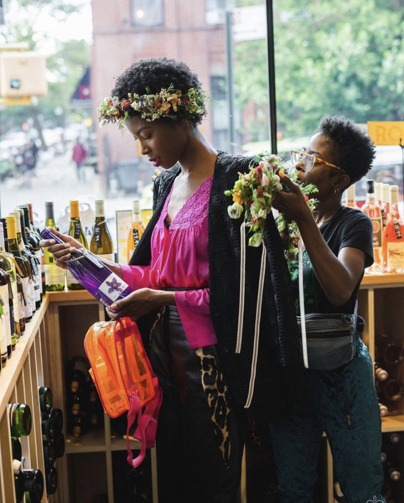 Brooklyn Blooms owner LaParis Phillips adorning a model in wearable flowers for a photo shoot in a Brooklyn wine shop