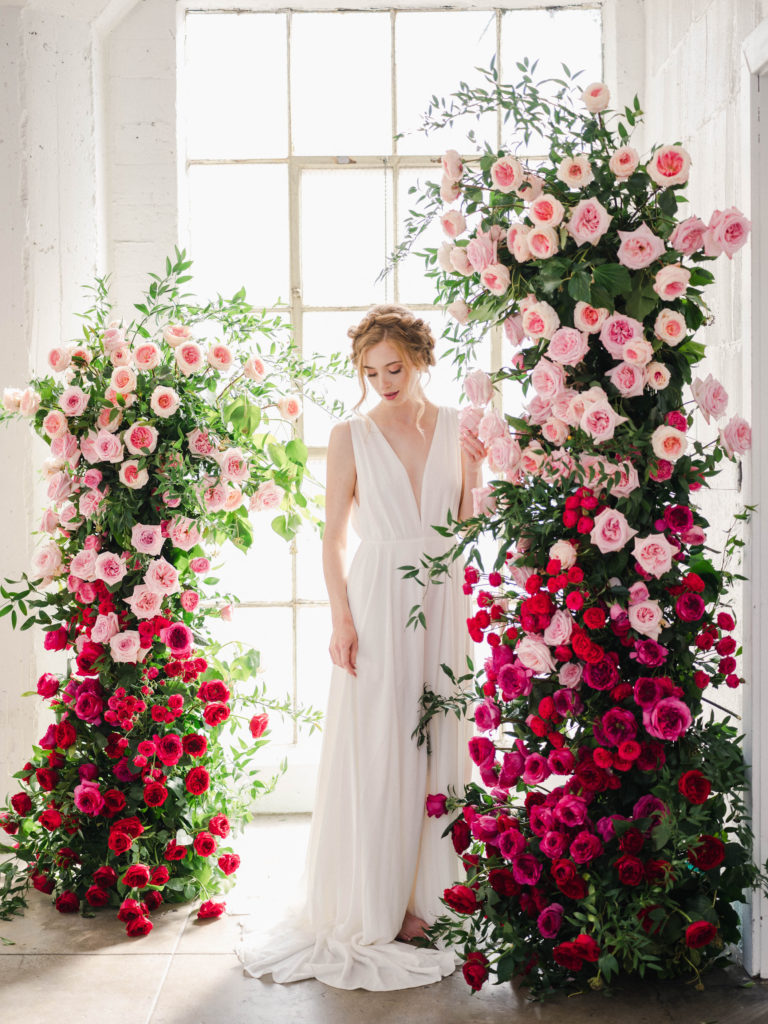 Bride standing between pillars of garden roses from Alexandra Farms