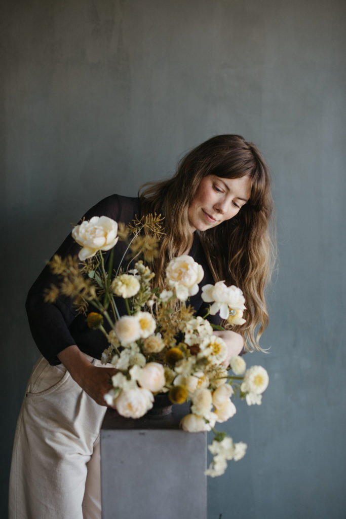 Color Theory Design Co. owner Alyssa Lytle arranging neutral colored flowers in her Portland studio