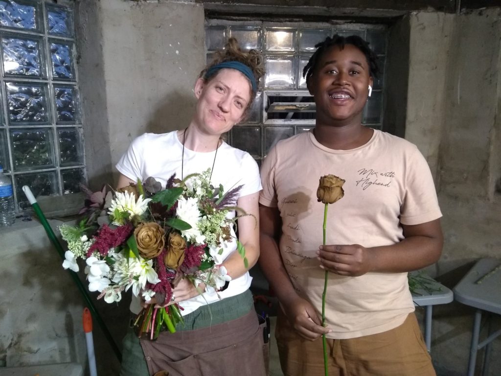 Hannah Bonham Blackwell holding a bridal bouquet and standing next to a young man who is a Southside Blooms team member