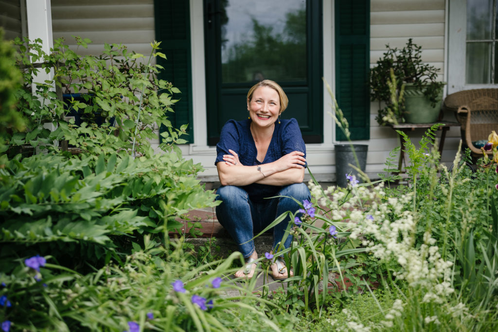 Marketing strategist Alison Ellis sitting on her porch surrounded by greenery