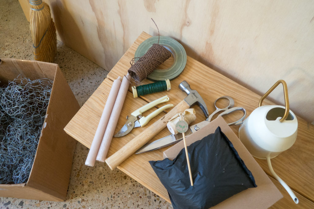 supplies needed to create an installation with OshunPouch laying on a worktable in a flower studio