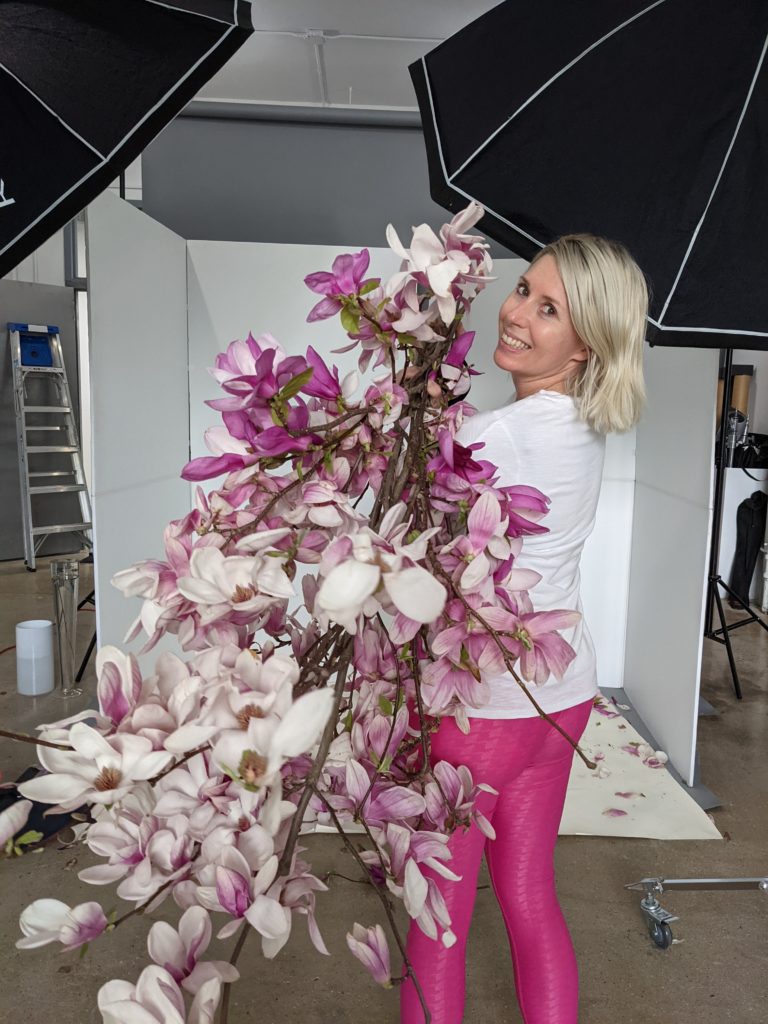 The owner of Cape Lily holding an armful of blooming magnolia branches