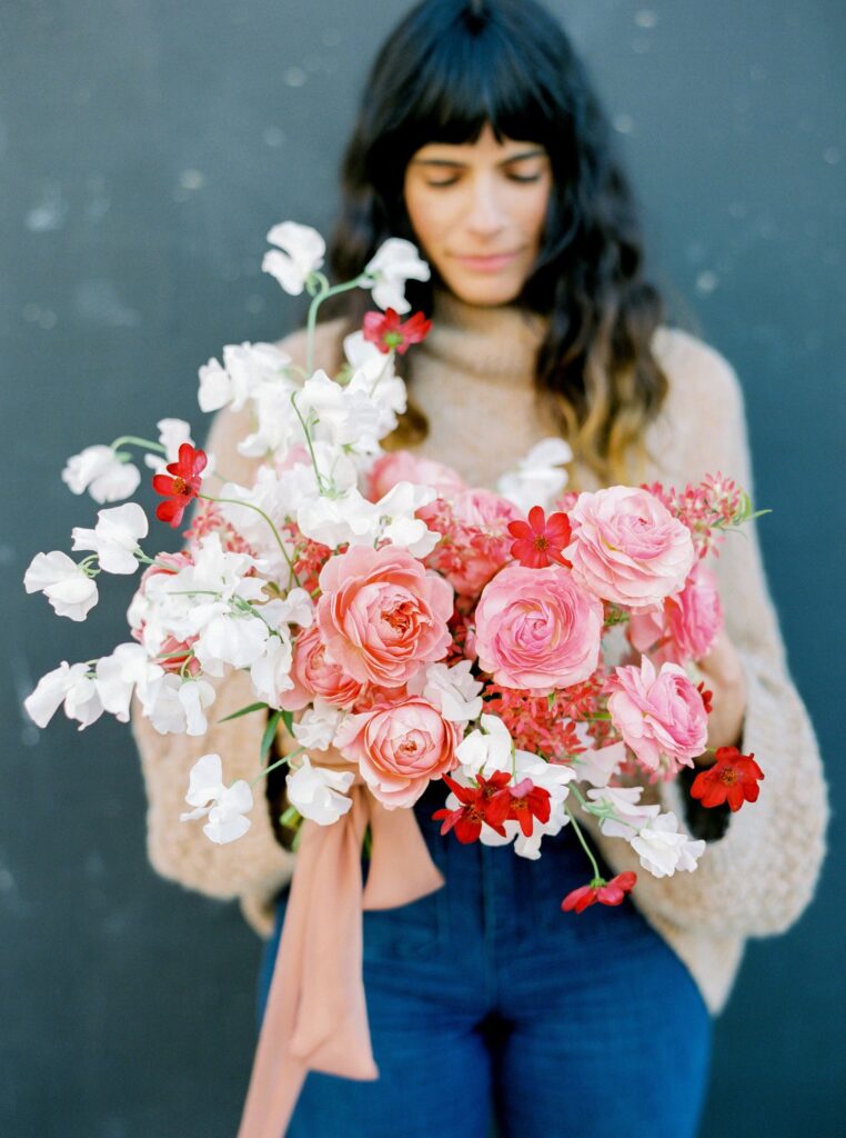 Floral artist Rachael Lunghi of Siren Floral Co holds a pink and white wedding bouquet she designed