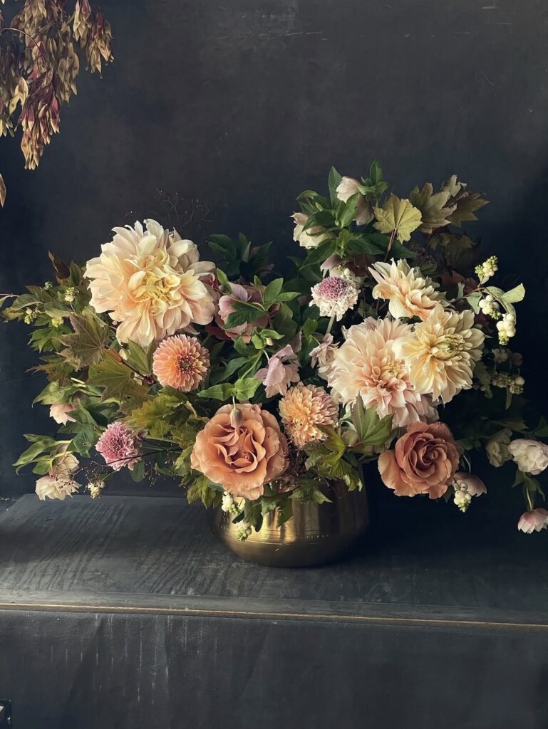 Flower shop arrangement of peach and cream flowers in a gold bowl from FLWR Shop in Nashville